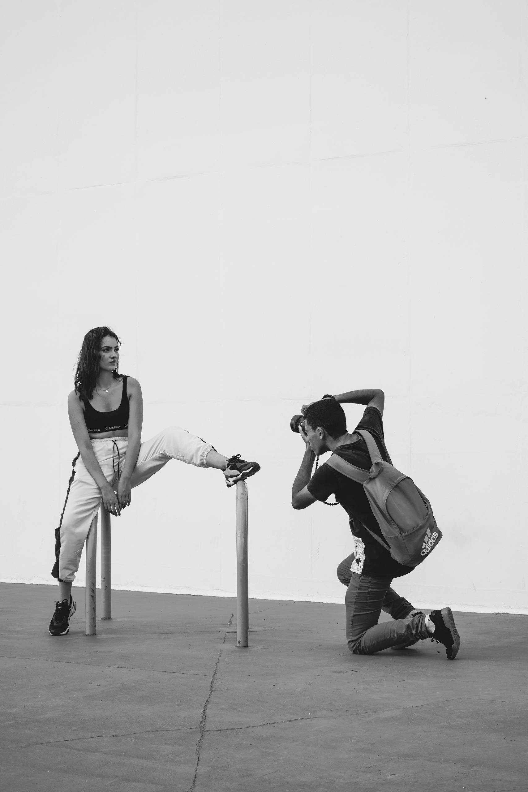 Black and white outdoor photo of a model posing for a photographer.
