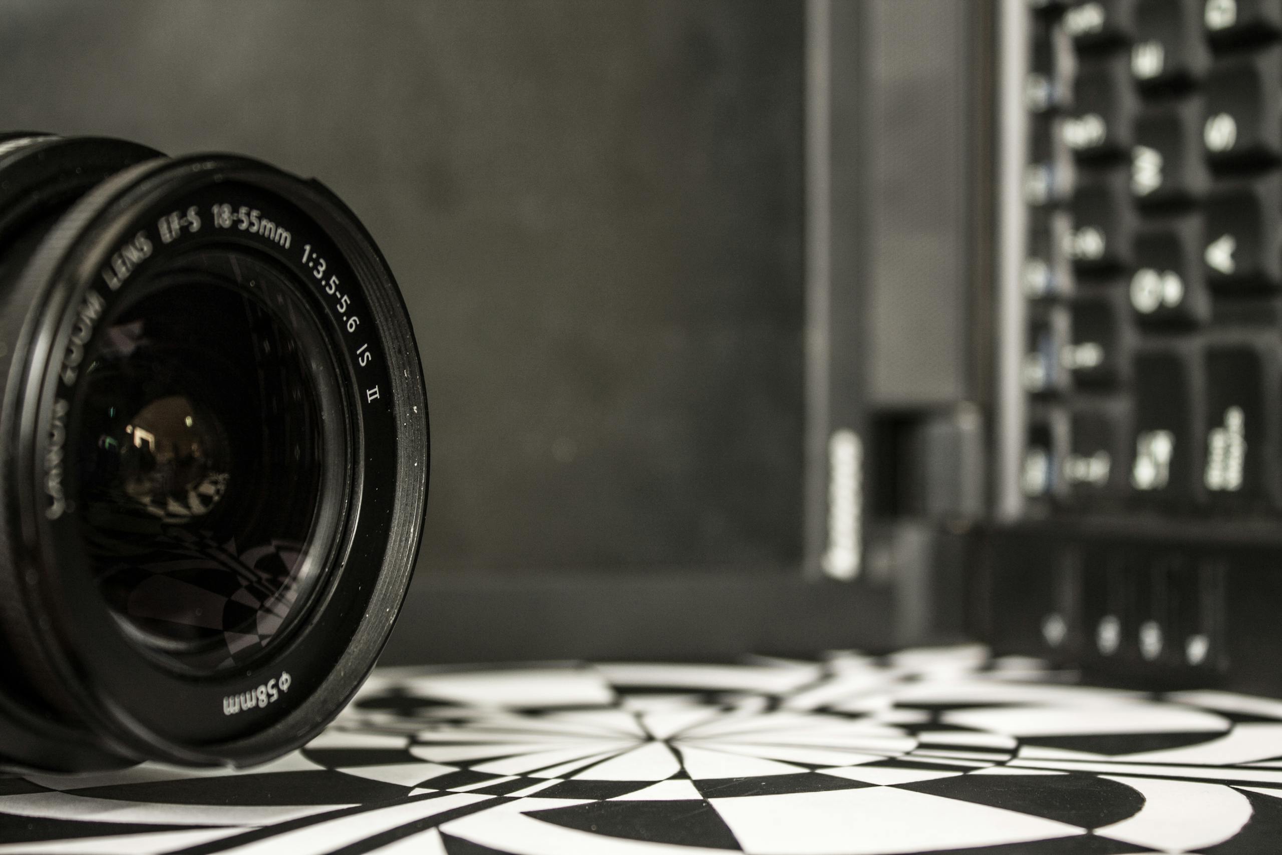 Detailed shot of a camera lens near a laptop keyboard, showcasing optical technology.